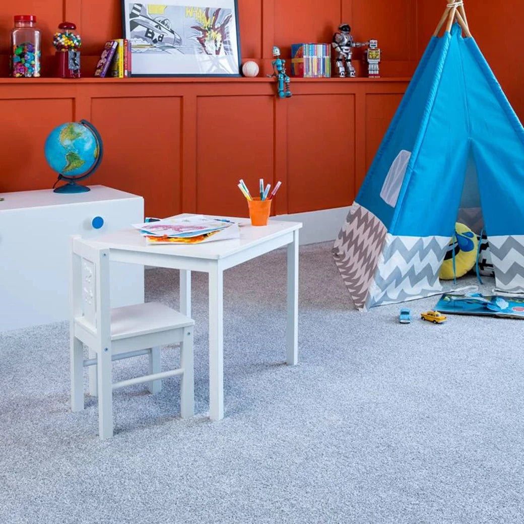 Children's room with a blue teepee, table, and various toys against an orange wall.